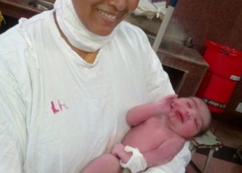 Sr. Nilam holding a newborn baby-  a part of her Nursing Training